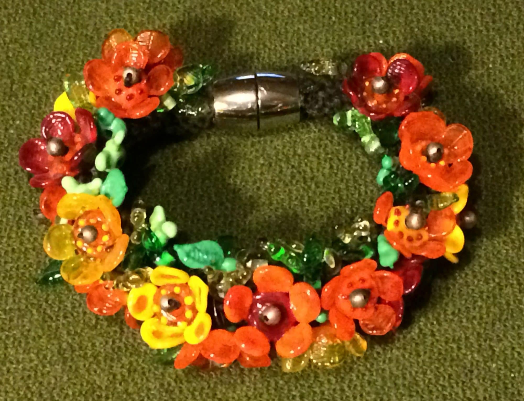 Strikket armbånd med orange blomster